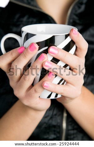 Pretty young woman holding a stripped coffee cup