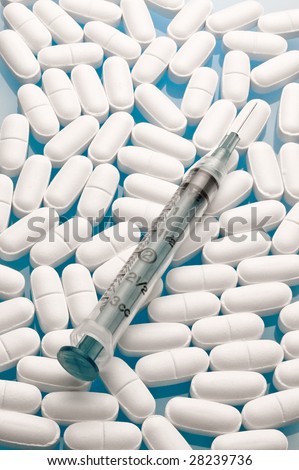 Close up of medical syringes against a white pill background