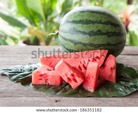 Sliced watermelon pieces placed on a wooden table.