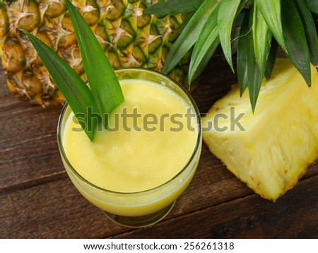pineapple juice and pineapple on wood table. for health