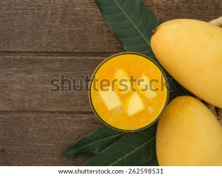 mango juice and mango on wood table. view above