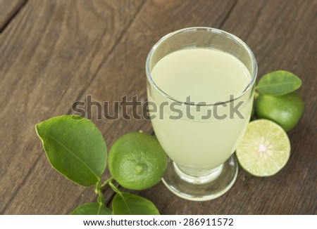 Preparation of the lemonade drink. Lemonade in the  glass and lemons on the table.