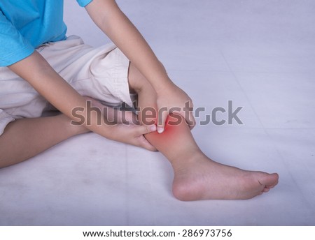 Calf leg pain, child holding sore and painful muscle, sprain or cramp ache filled with red bright place. Person injured when exercising or playing.
