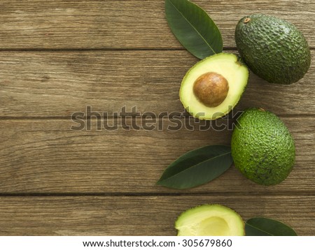 avocado and Sliced avocado slices on a dark wood background.