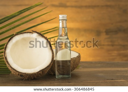 coconut oil and fresh coconuts on wooden table.