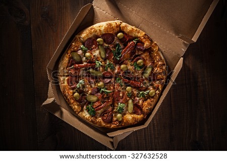 pizza in the in delivery box top view on the wood