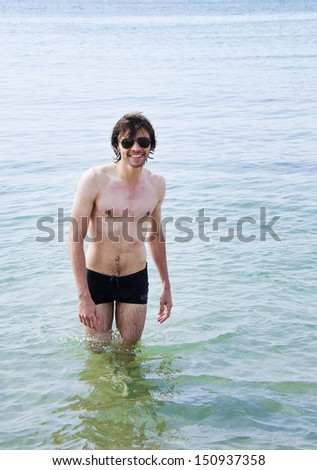 Young handsome man walking out of the sea