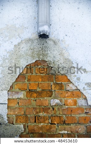 Old broken rain water pipe (drain) with a damaged wall