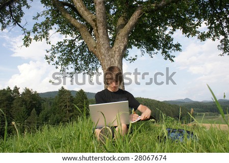 Male university student using laptop outside