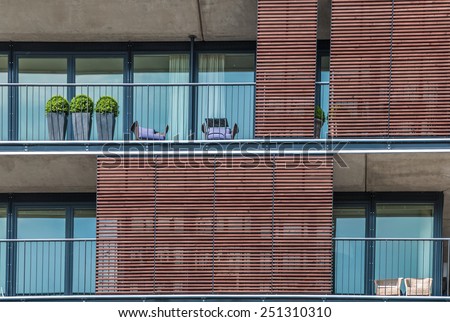 Three topiary trees on an apartment balcony in Hamburg Germany Three topiary trees in flowerpots standing in a row on an apartment balcony, closeup view of the exterior of the building
