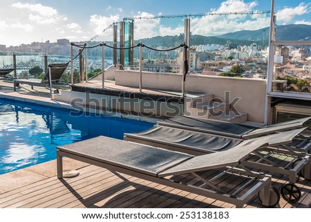 Architectural Swimming Pool at Building Rooftop with Lounge Area\
Tranquil Modern Architectural Swimming Pool with Lounge Chairs on the Side at the Building Rooftop Under a Cloudy Sky.