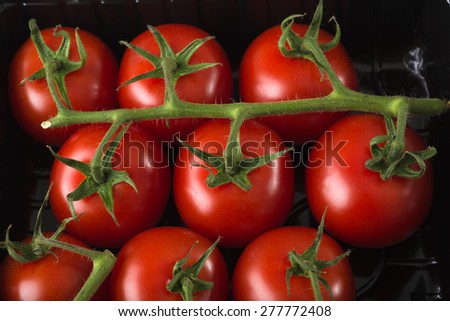 Aerial view fresh red tomatoes in black supermaket plastic tray \
Clean eating organic food for healthy cooking low carb and low fat detox diet closeup