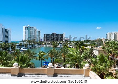 Luxury resort buildings at Sarasota Bay in Florida USA. \
Architectural residential condominiums for holidays and vacation with palm trees against blue sky background