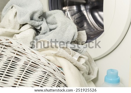 Towels in the laundry basket in front of the washing machine