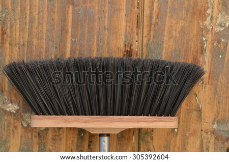 Broom in front of old wooden wall