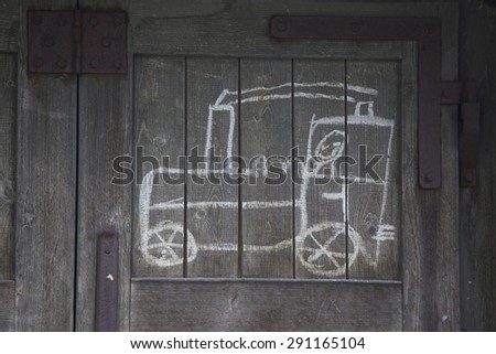 childs drawing of a train on an old wooden wall