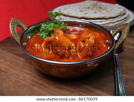 A typical Indian take away of Chicken Tikka Masala with naan breads.