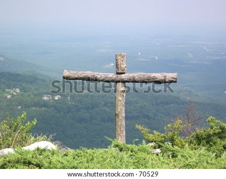 A cross made of logs on a mountainside