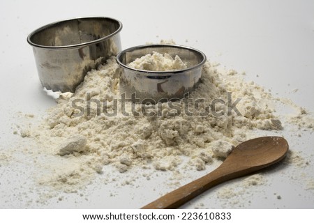 pastry cutters and flour on white wooden board