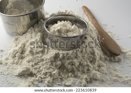 pastry cutters and flour on white wooden board