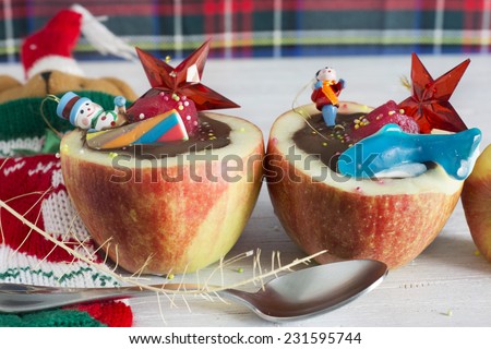 Apples stuffed with chocolate. Dice fruit, impregnating in you red fruit, candy and toys. Healthy Child Christmas dessert