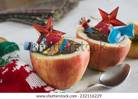 Apples stuffed with chocolate. Dice fruit, impregnating in you red fruit, candy and toys. Healthy Child Christmas dessert