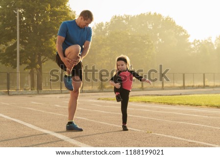 Fathe and daughter go in sports.Child at the stadium.Jogging family.Man and girl.Family spending time together.Child education.