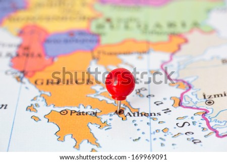 Round red thumb tack pinched through city of Athens on Greece map. Part of collection covering all major capitals of Europe.