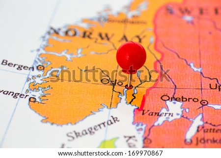 Round red thumb tack pinched through city of Oslo on Norway map. Part of collection covering all major capitals of Europe.