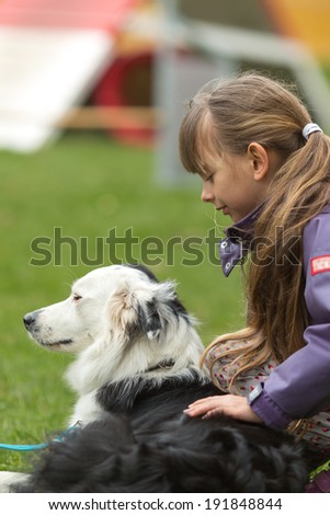 Girl patting a white and black purebred border collie dog.