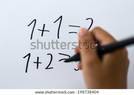 Close-up of simple math written on white piece of paper.
