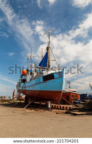 Medium-sized fishing boat standing in a drydock for repairs.