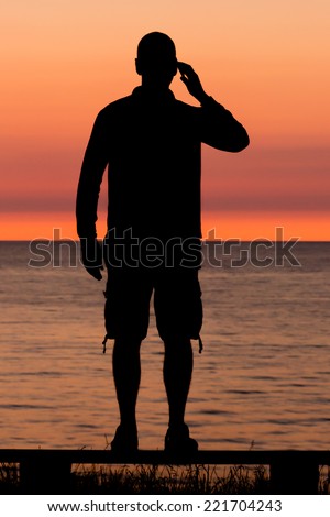 Silhouette of male person against a colorful horizon.