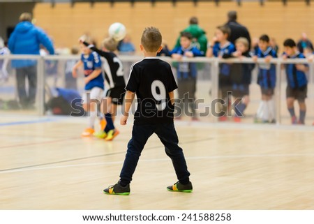 Young northern european boys playing a indoors soccer training match inside an indoor sports arena.