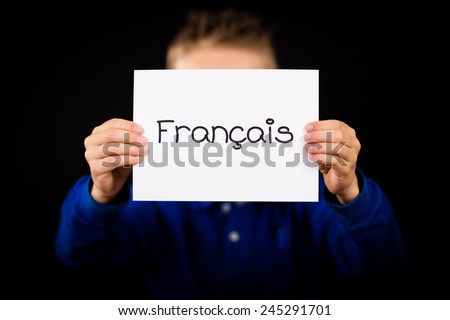 Studio shot of child holding a sign with French word Francais - French