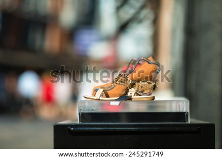 A shoe with high heel on display outside a footwear store.