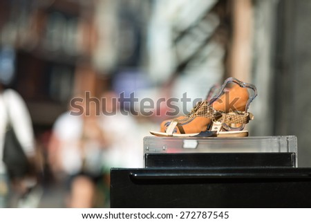 A shoe with high heel on display outside a footwear store.