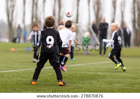 Young caucasian boys during a kids soccer training session on green turf.