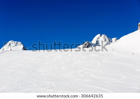 Fresh ski tracks on ski slope with new white snow at the ski resort Soelden in the Austrian Alps.