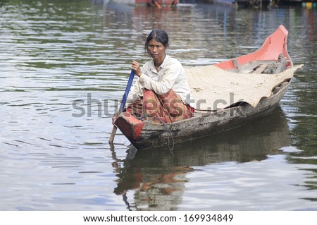 TON LE SAP,CAMBODIA, 24 DEC 2011-Unidentified Cambodian woman rowing her sampan in Ton le Sap water village, Siam Reap,Cambodia on 24 Dec 2011