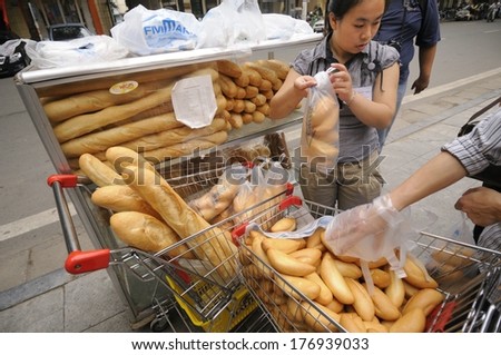 HANOI, VIETNAM - MAY 24: An unidentified road side baguette seller sells fresh baguettes in Hanoi on May 24, 2011