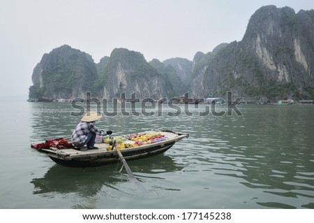 HA LONG BAY, VIETNAM - MAY 25: Unidentified woman sells fruits from her boat on Ha Long bay, Vietnam on May 25, 2011. Floating markets are very popular as it is only way to move around.