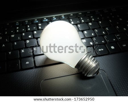 Light bulb that is lit on your computer keyboard as symbol of new ideas in computing and electronics.