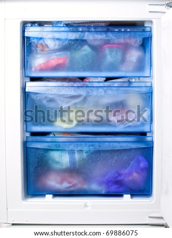 View of the inside of a freezer full of various frozen foodstuff.