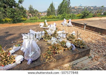 Wilting flowers placed on top of the mass graves and tombs of 500,000 murdered tutsi tribespeople at the Rwandan Genocide Memorial in Kigali, Rwanda (Kigali is seen in the background)