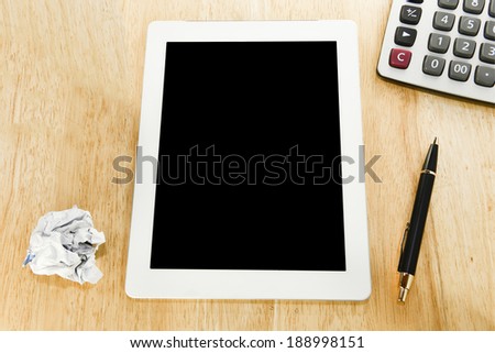 Workplace with blank digital tablet,calculator, pen and  paper crumpled on work table top view