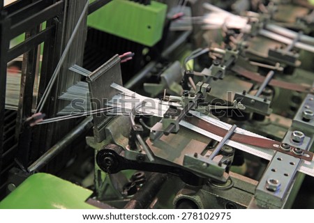 Machine for knitting textile tape on two lines