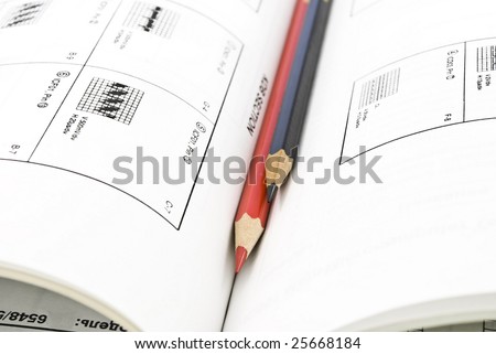 Red and black pencils and book