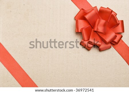 Gift packaging with red ribbons and bow on cardboard background