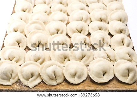 Raw meat dumplings on wooden plate